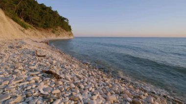 Karadeniz 'de gün batımı. Çakıl taşı plajı ve kayalık kıyılar.