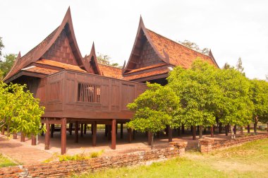 thai house kırmızı tuğla duvarlarla çevrili ahşap bina