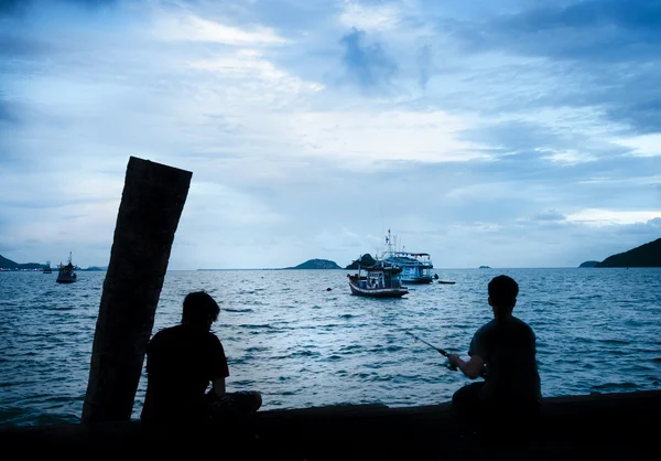 Silhuetas dos meninos que estão pescando — Fotografia de Stock