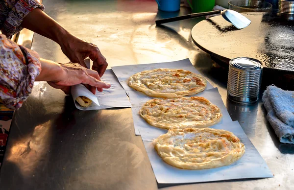 Human hands cooking roti fried bread with butter and parsley — Stock Photo, Image