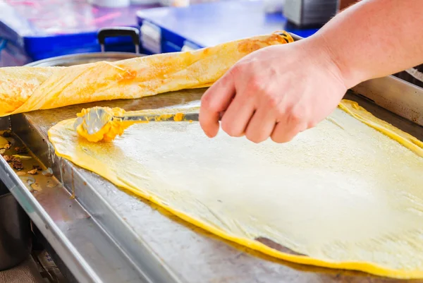 Man making indian food by buttered flat bread roti in pan — Stock Photo, Image