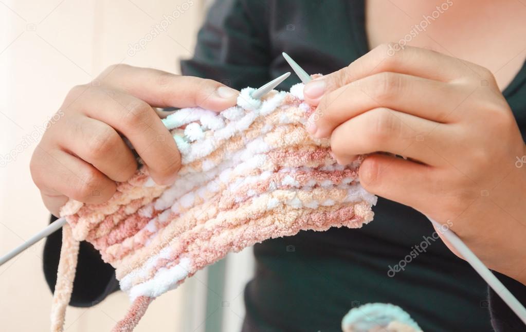Hands of woman knitting with wool