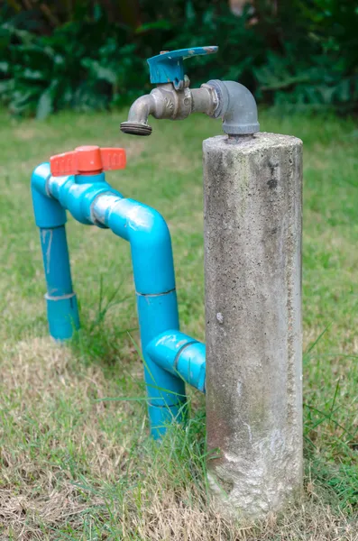 Water tap in garden with grass background — Stock Photo, Image