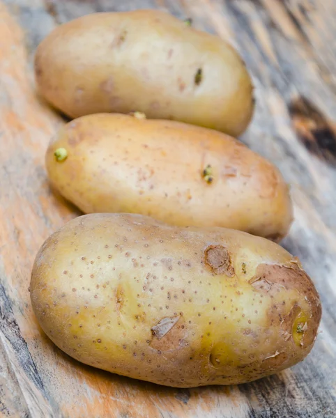 Fresh potatoes on a wooden chopping board — Stock Photo, Image