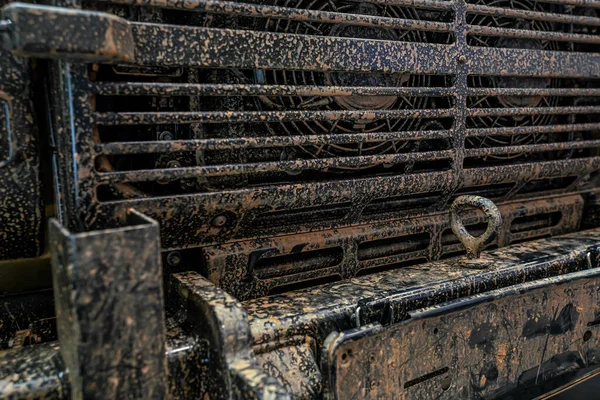 Voorzijde militaire 4wd voertuig, metalen rooster bedekt met droge modder en roest, close-up detail — Stockfoto