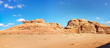 Rocky Massifs kırmızı kum çölünde, parlak mavi gökyüzü arka planda - tipik Wadi Rum, Ürdün manzarası.