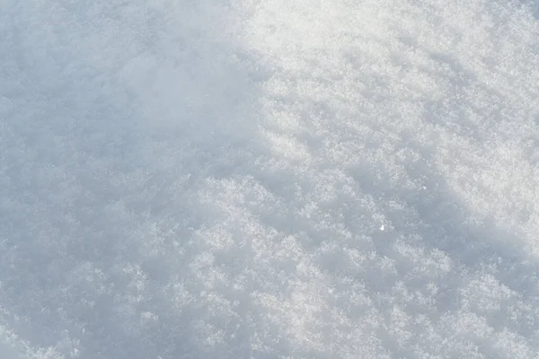 Soleil brille sur le sol recouvert de neige formant de petites collines - détail macro gros plan — Photo