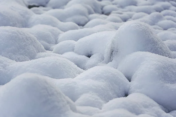 Round rocks near river covered with layer of snow — Stock Photo, Image