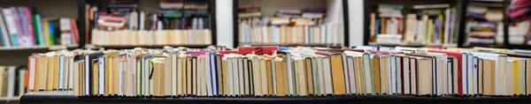 Rangée de nombreux vieux livres d'occasion exposés à la librairie antiquaire locale, mise au point photo large sur le côté droit — Photo