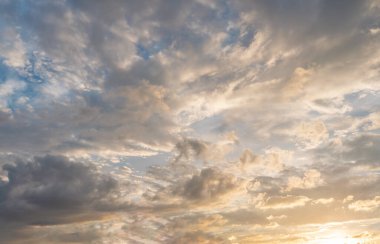 Sabah mavi turuncu gökyüzü, güneş bulutların arasında parlıyor.