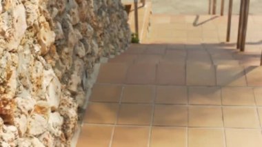 Güneşli bir günde kahverengi döşemeli merdivenlerden inerken yere bakıyorum.