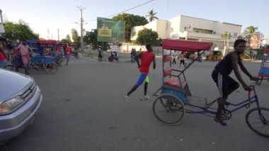 Toliara, Madagaskar - 01 Mayıs 2019: Meşgul kavşaktaki tipik akşam sahnesi, insanlar yürüyor, bisikletli fayton geçiyor, yakınlardan geçiyor