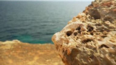 Kayaların üzerinden denize doğru ilerlerken, sonunda yeşil suya bakın.