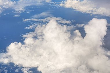 Öğleden sonra güneşiyle aydınlanan yumuşak gökyüzü bulutları üzerinde uçan ticari uçaklardan görüldüğü gibi.