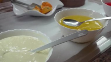 Porselen tabaklar ve kaseler çeşitli jöleli tatlılar, meyveler ve kekler açık büfe restoranında sergileniyor.
