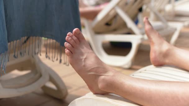 Young Man Sunbathing White Plastic Sunbed Detail His Feet Beach — Stock video