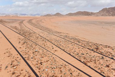 Eski tren rayları Wadi Rum, Ürdün 'de neredeyse tamamen çöl kumuyla kaplıydı..