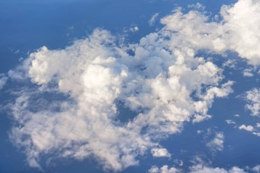 Öğleden sonra güneşiyle aydınlanan yumuşak gökyüzü bulutları üzerinde uçan ticari uçaklardan görüldüğü gibi.