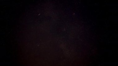 Gece vakti gökyüzü, uyduları olan pek çok yıldız, Kartal nebulası belli belirsiz görünür.