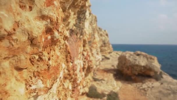 Okyanus Kıyısındaki Kayaların Yanında Yürümek Uzak Mesafedeki Sakin Deniz — Stok video