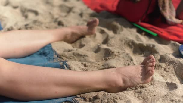 해변에서 일광욕을 여자가 모래를 빼내려고 발짓을 신경을 발짓을 — 비디오