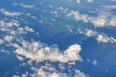 Öğleden sonra güneşiyle aydınlanan yumuşak gökyüzü bulutları üzerinde uçan ticari uçaklardan görüldüğü gibi.