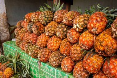 Madagaskar 'daki sokak pazarında sergilenen taze ananas yığını.