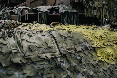 Armoured military vehicle camouflage cover - tarpaulin mesh, closeup detail.