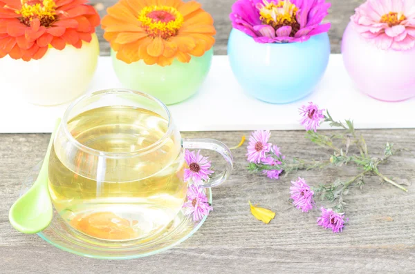 Tea cup with different flowers on wood — Stock Photo, Image