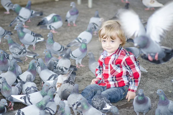 Bambino circondato da colombe — Foto Stock