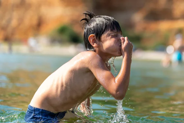 Menino Bonito Brincando Nadando Mar Segurando Nariz Com Água Salpicando — Fotografia de Stock