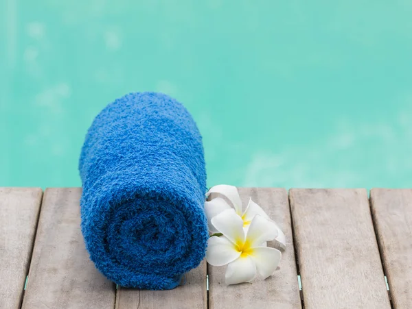 Serviette bleue et fleur au bord de la piscine — Photo