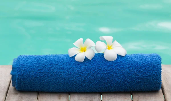 Μπλε πετσέτα και λουλούδι δίπλα στην πισίνα — Φωτογραφία Αρχείου