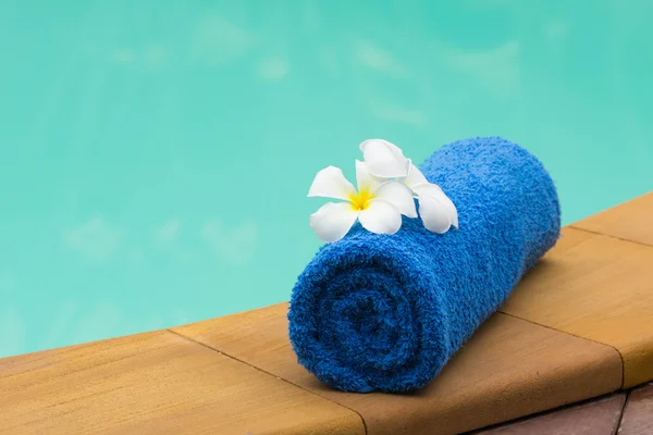 Blaues Handtuch und Blume am Pool Stockfoto