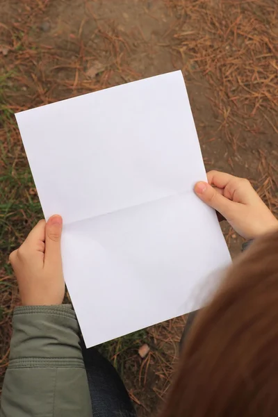 Een vel papier in zijn handen — Stockfoto