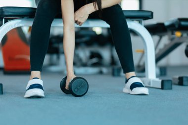 Fitness kızı spor salonunda dambılı kaldırıyor. Spor ve kas konsepti.