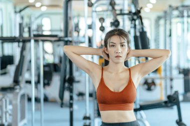 Spor giyim eğitiminde Asyalı bir kadın spor salonunda oturuyor. Fitness ve egzersiz konsepti.