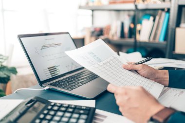 İş adamı ofis masasında çalışıyor ve yeni muhasebe finans projesini analiz ediyor. Yatırım, Mali Danışmanlık ve Muhasebe Konsepti.