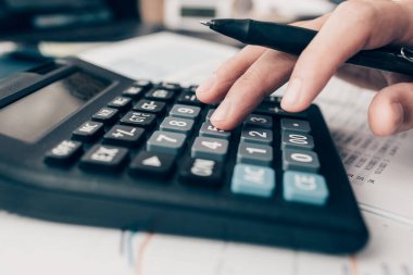 Finans işadamı, şirketlerin vergi vergilerini hesaplamak ve finansal tabloları analiz etmek için hesap makinesi kullanıyor. finans ve muhasebe kavramı.