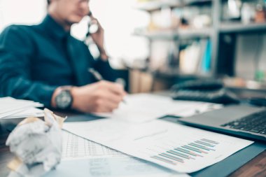 Veri tablosu üzerine bir kalem ve ofis masasında çalışan bir iş adamı ve yeni muhasebe finansmanı projesini analiz eden bir kalem. Yatırım, Mali Danışmanlık ve Muhasebe Konsepti.