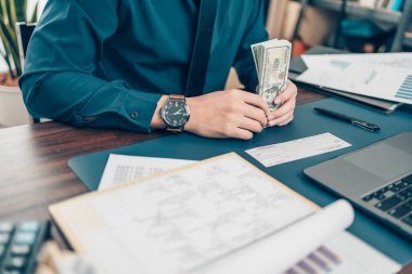 İşadamı el yazısı ve imzası beyaz boş banka defteri ve dolar fatura, para, dizüstü bilgisayar ve grafik çizelgesi ofisteki masada. Çek ile ödeme, maaş çeki, maaş kavramı.