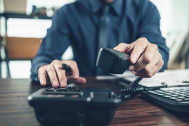 İş adamı ofisteki masabaşını arıyor. Telefon arama, iletişim ve müşteri hizmetleri.