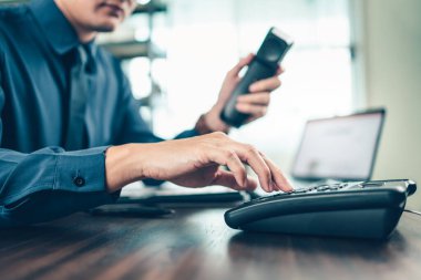 İş adamı ofisteki masabaşını arıyor. Telefon arama, iletişim ve müşteri hizmetleri.