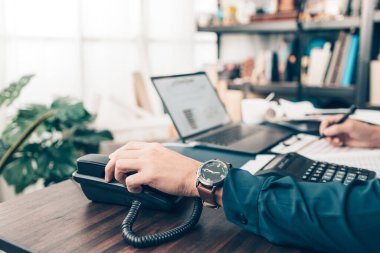 İş adamı ofisteki masabaşını arıyor. Telefon arama, iletişim ve müşteri hizmetleri.