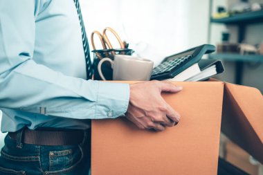 İşsiz tutulan karton kutu ve istifa mektubu, dosya, alam saat, kahve fincanı, hesap makinesi ve kutuda çizim tüpü. İşten ayrılan işadamı, ya kovuldu ya da işten atıldı.