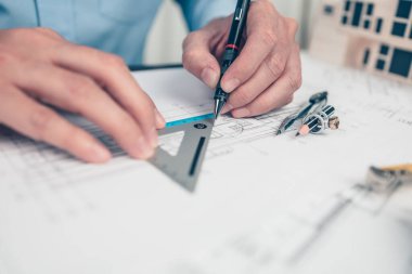 Architect engineer use pencil and triangular angle ruler  drawing design working on bueprint. House planning design and construction concept.