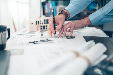 Mimar mühendis bueprint üzerinde çalışırken kalem ve açı koruyucu çizim tasarımı kullanır. Ev planlama ve inşaat konsepti.