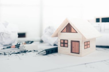 Mini model ev, kalem, pusula ve tasarım planının taslağı. Mimar ve mühendis konsepti.
