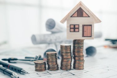 Mini model ev, para, kalem, pusula ve tasarım planları. Maliyet Mimarı ve Mühendislik kavramı.