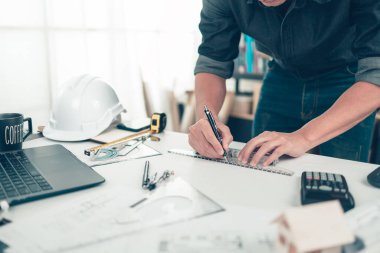 Mimar mühendis, bueprint üzerinde çalışırken kalem ve mini T-slide tasarımı kullanır. Ev planlama ve inşaat konsepti.